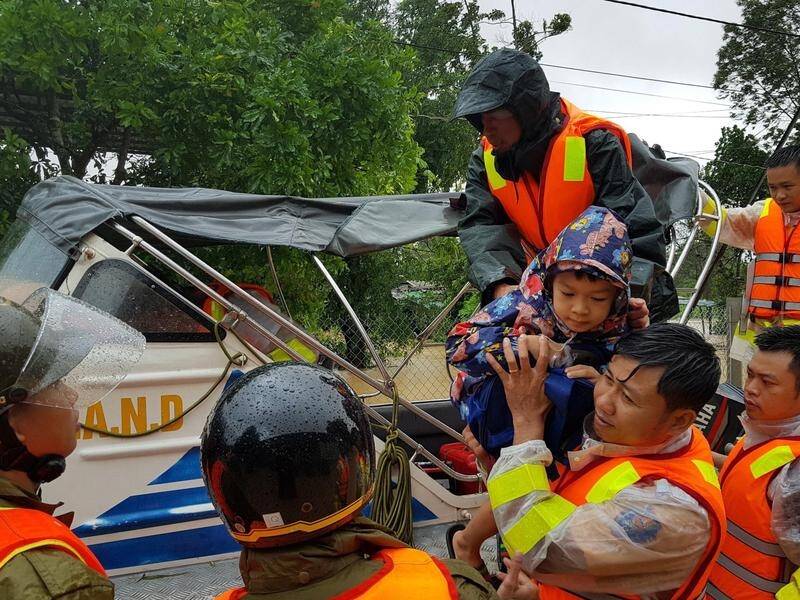 Municipal workers evacuate local people from flood water in Quang Tri province, Vietnam.