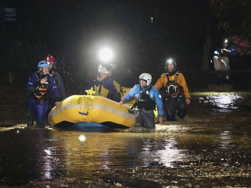 Emergency workers use an inflatable boat to rescue stranded residents in Nelson, New Zealand. (AP PHOTO)