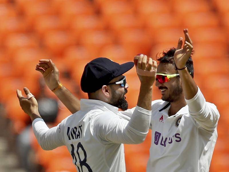 India's Axar Patel (r) celebrates with captain Virat Kohli after dismissing England's Ben Stokes.