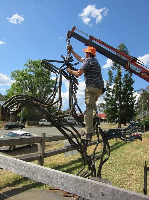 PREPARATION: Artist Tobias Bennett securing his work Rearing Horse.