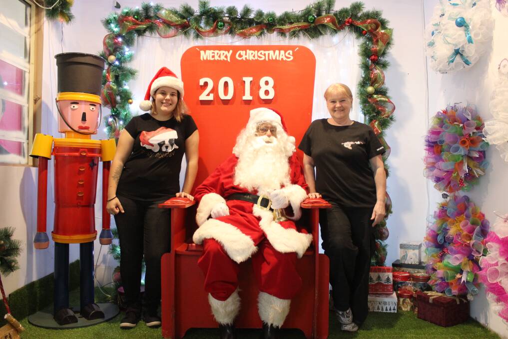 SMILE: The Coffee Shot Cafe's Gabrielle Vanderschaaf (left) and Julie Myers (right) with Santa Claus. Picture: Stephen Bisset