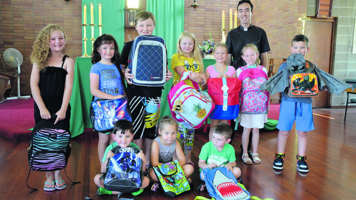 SPECIAL SERVICE: At back, Shae Smith, Charlotte Morrow, Seth Wilton, Abby Wilton, Sibella Davies, Father Chris Jackson, Kaity Cherry, Patrick Bennett, and at front, Marcus Morrow, Charlotte Newell, Jai Smith with their backpacks, which will be blessed at St Paul’s Kurri this Saturday.