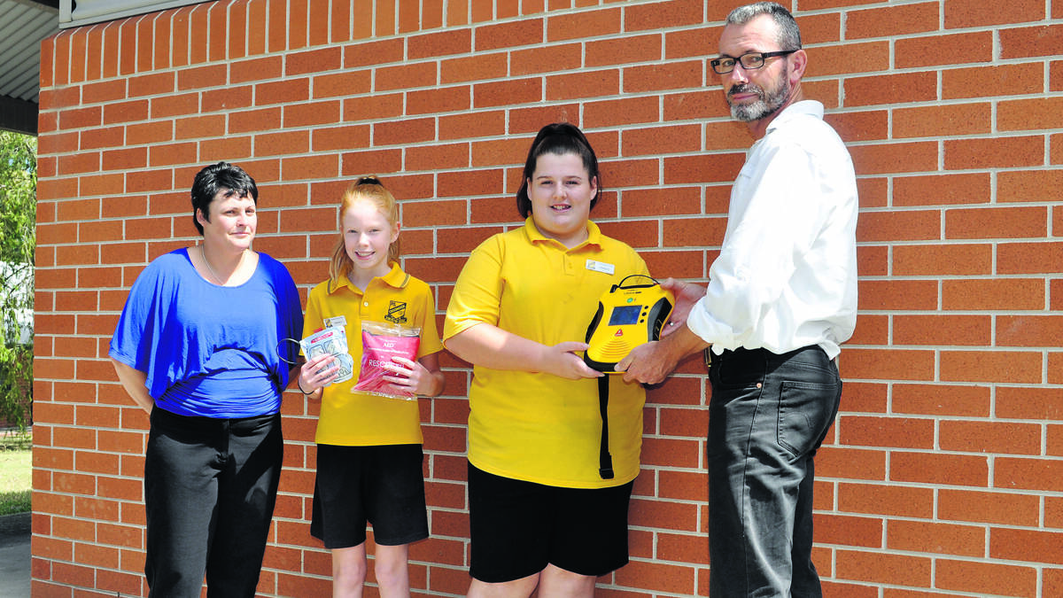 LIFE-SAVING DEVICE: Australian Red Cross trainer Tracey Ellem, Cessnock Public School prefects Hannah Pringle and Leigha Wilson and assistant principal Glenn Burrell with the school’s new defibrillator.