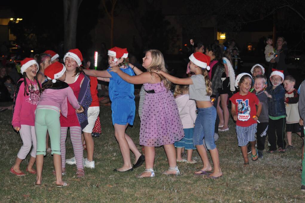 Children start a conga line at Carols in the Park, Cessnock TAFE grounds, December 6.