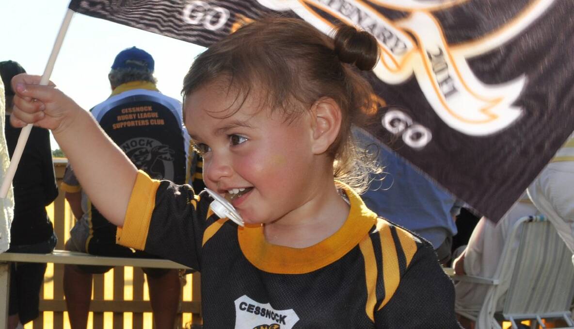 Layla White, 18 months, cheers on her dad Mark White in his last game for the Goannas. Photo: Melanie Adams.