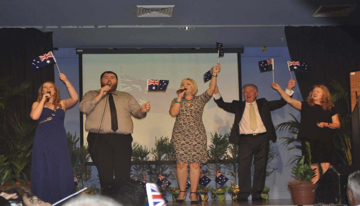 Performers Hayley Doherty, Michael King and Tar Naysmith  with Master of Ceremonies, Phill Collins and Pauline Ross from Cessnock Council, during the performance of 'I am Australian'. 