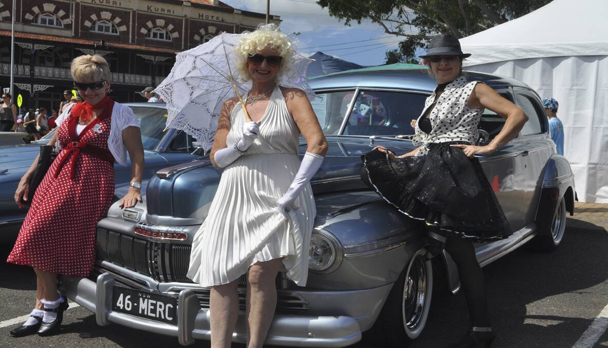 Tracy Barwick (Floraville), Robyn Kachel (Caves Beach) and Chris Sutton (Singleton) posing with Peter Howels 1946 Ford Merc. 
